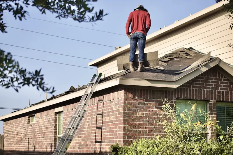 Professional roofer working on a residential roof in Golfview